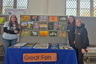 Photography stall display, interns amd staff member smiling at the camera